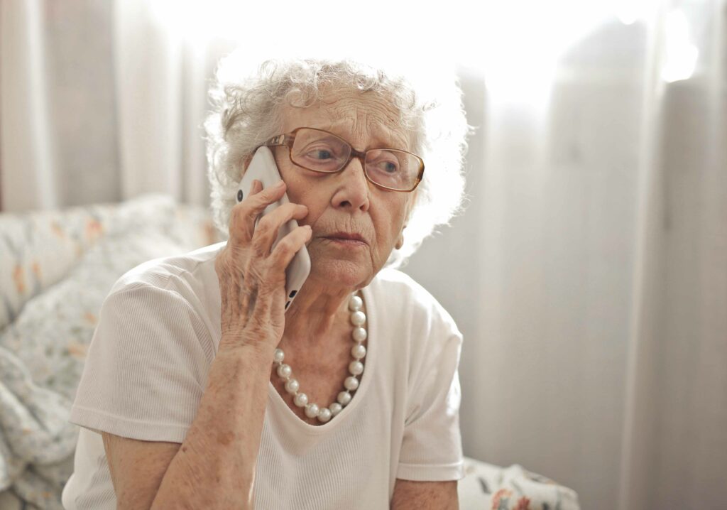 Elderly woman on phone talking to someone.